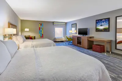 a hotel room with two beds and a television at Hampton Inn Cincinnati Airport-North in Hebron