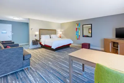 a hotel room with a bed and a couch at Hampton Inn Cincinnati Airport-North in Hebron