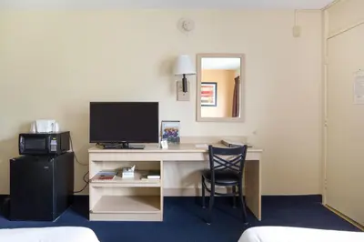 a desk with a computer and a chair in a room at Days Inn by Wyndham New Philadelphia in New Philadelphia