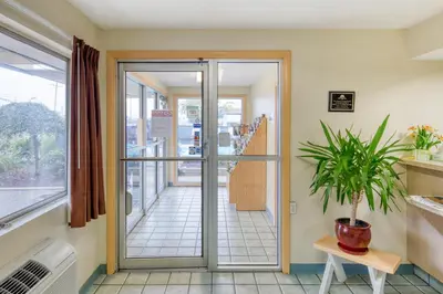a hallway with a glass door and a plant at Days Inn by Wyndham New Philadelphia in New Philadelphia