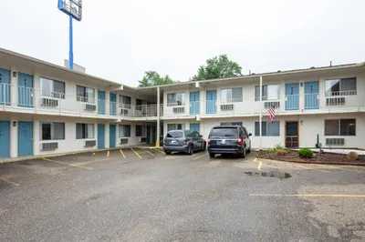 a hotel with two cars parked in a parking lot at Days Inn by Wyndham New Philadelphia in New Philadelphia