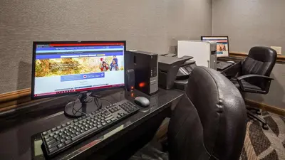 a desk with a computer monitor and a keyboard and mouse at Best Western Plus North Canton Inn & Suites in North Canton