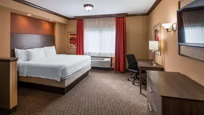 a hotel room with a bed and a desk and a television at Best Western Plus North Canton Inn & Suites in North Canton