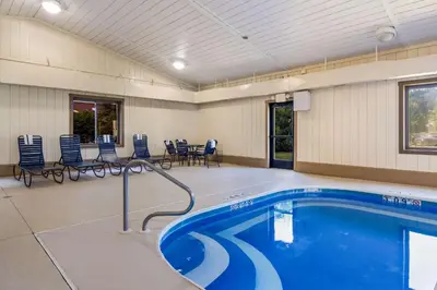 a swimming pool in a room with chairs and tables at Best Western Dutch Valley Inn in New Philadelphia