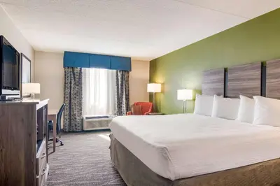 a hotel room with a large bed and a flat screen tv at Best Western Dutch Valley Inn in New Philadelphia