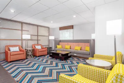 a lobby with yellow and orange chairs and a couch at Hampton Inn Akron-South in Akron