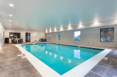 a large swimming pool with blue water in a building at Hampton Inn Akron-South in Akron