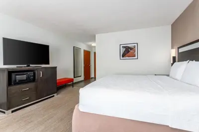 a hotel room with a bed and a flat screen tv at Hampton Inn Akron-South in Akron