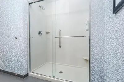 a shower with a glass door in a bathroom at Hampton Inn Akron-South in Akron