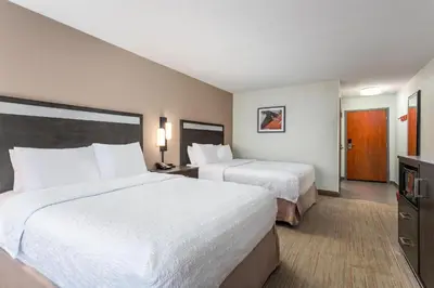 a hotel room with two beds and a television at Hampton Inn Akron-South in Akron