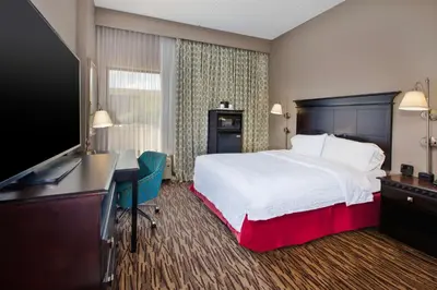 a hotel room with a bed and a desk and a television at Hampton Inn & Suites Cleveland-Airport/Middleburg Heights in Middleburg Heights