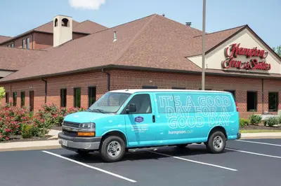 a blue van parked in a parking lot in front of a building at Hampton Inn & Suites Cleveland-Airport/Middleburg Heights in Middleburg Heights