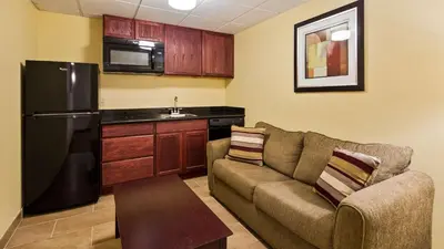 a living room with a couch and a kitchen at Best Western Airport Inn & Suites Cleveland in Brook Park