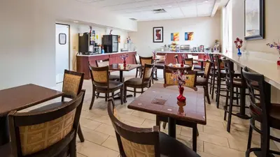 a restaurant with tables and chairs and a bar at Best Western Airport Inn & Suites Cleveland in Brook Park