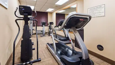 a gym with several tread machines in a room at Best Western Airport Inn & Suites Cleveland in Brook Park
