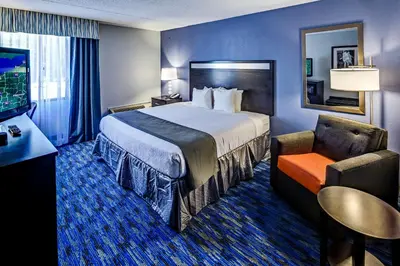 a hotel room with a bed and a chair at Holiday Inn Cleveland Northeast - Mentor by IHG in Mentor