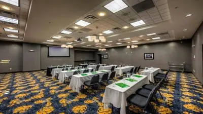 a banquet hall with white tables and black chairs at Holiday Inn Cleveland Northeast - Mentor by IHG in Mentor