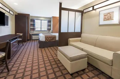 a room with a couch and a bed and a desk at Microtel Inn and Suites North Canton in North Canton