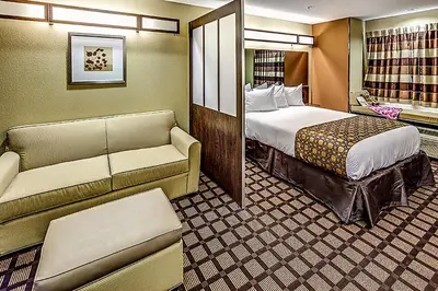 a hotel room with a bed and a couch at Microtel Inn and Suites North Canton in North Canton