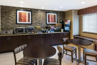 a restaurant with two tables and chairs and a counter at Microtel Inn and Suites North Canton in North Canton