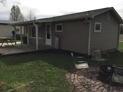 a house with a patio and chairs in the yard at Martin's River Cabin in Dresden