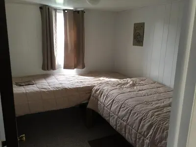 a small bedroom with two beds and a window at Martin's River Cabin in Dresden