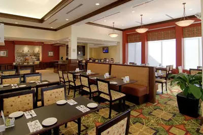 a restaurant with tables and chairs and a bar at Hilton Garden Inn Cleveland East / Mayfield Village in Mayfield