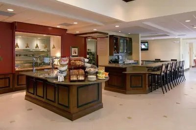 a restaurant with a counter with food on it at Hilton Garden Inn Cleveland East / Mayfield Village in Mayfield