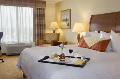 a hotel room with a tray of food on a bed at Hilton Garden Inn Cleveland East / Mayfield Village in Mayfield