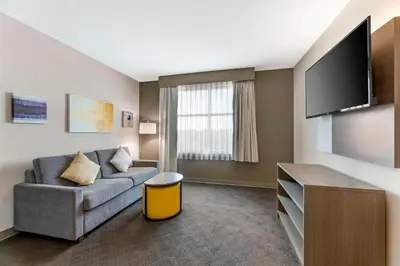 a living room with a couch and a flat screen tv at Comfort Inn & Suites Cuyahoga Falls - Akron in Cuyahoga Falls