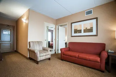 a living room with a red couch and a chair at Comfort Inn & Suites Cuyahoga Falls - Akron in Cuyahoga Falls