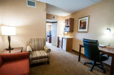 a hotel room with a desk and a chair and a table at Comfort Inn & Suites Cuyahoga Falls - Akron in Cuyahoga Falls