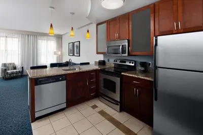 a kitchen with stainless steel appliances and wooden cabinets at Residence Inn by Marriott Cincinnati Downtown/The Phelps in Cincinnati