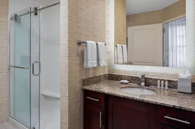 a bathroom with a sink and a shower with a mirror at Residence Inn by Marriott Cincinnati Downtown/The Phelps in Cincinnati