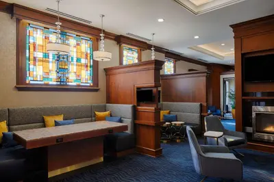 a waiting room with a table and chairs and a stained glass window at Residence Inn by Marriott Cincinnati Downtown/The Phelps in Cincinnati