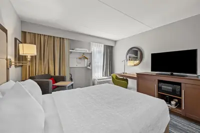 a hotel room with a bed and a flat screen tv at Hampton Inn Toledo-South/Maumee in Maumee
