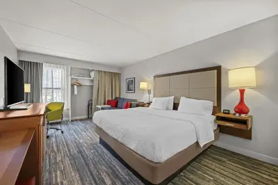 a hotel room with a large bed and a desk at Hampton Inn Toledo-South/Maumee in Maumee