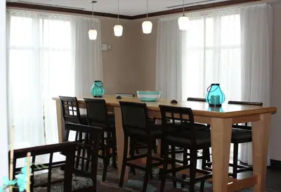 a dining room table with chairs and blue vases on it at Hampton Inn Gallipolis in Gallipolis