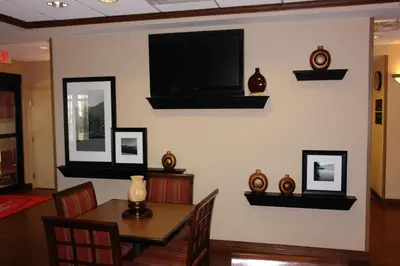 a dining room with a table and a television on a wall at Hampton Inn Gallipolis in Gallipolis