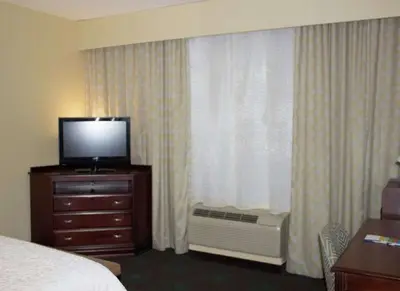 a hotel room with a television on a dresser with a window at Hampton Inn Gallipolis in Gallipolis