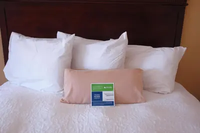 a bed with white pillows and a sign on it at Hampton Inn Gallipolis in Gallipolis