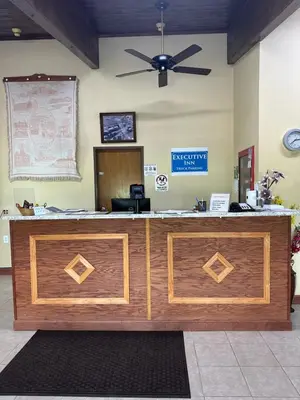an office with a reception desk with a ceiling fan at Executive Inn in Zanesville