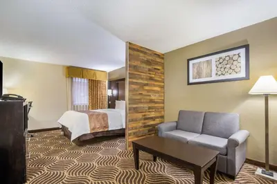 a hotel room with a bed and a couch at Quality Inn & Suites Florence - Cincinnati South in Florence