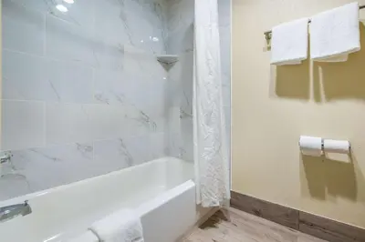 a white bathroom with a tub and a shower at Quality Inn & Suites Florence - Cincinnati South in Florence