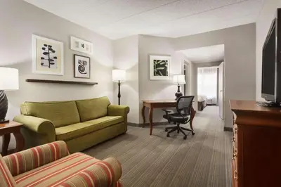 a living room with a green couch and a desk at Country Inn & Suites by Radisson, Lexington, KY in Lexington
