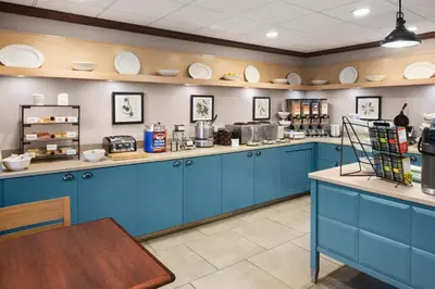 a large kitchen with blue cabinets and a table at Country Inn & Suites by Radisson, Lexington, KY in Lexington