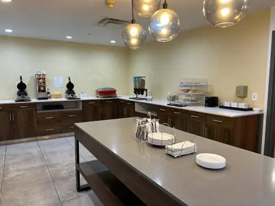 a large kitchen with a table with plates on it at Comfort Inn & Suites Toledo North in Toledo