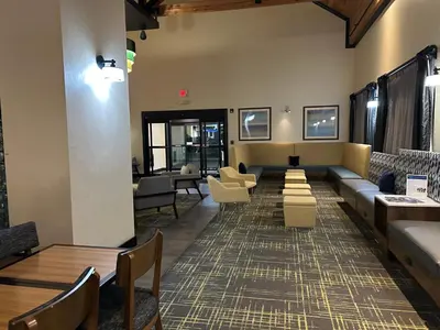 a waiting room with couches and tables and chairs at Comfort Inn & Suites Toledo North in Toledo