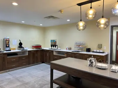 a large kitchen with wooden cabinets and a table at Comfort Inn & Suites Toledo North in Toledo
