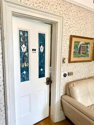 a white door with stained glass windows next to a couch at Historic Sion Bass Guest House in Fort Wayne